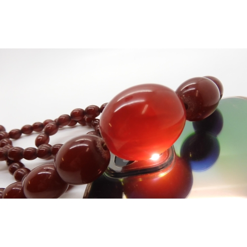 596 - A string of cherry amber coloured beads