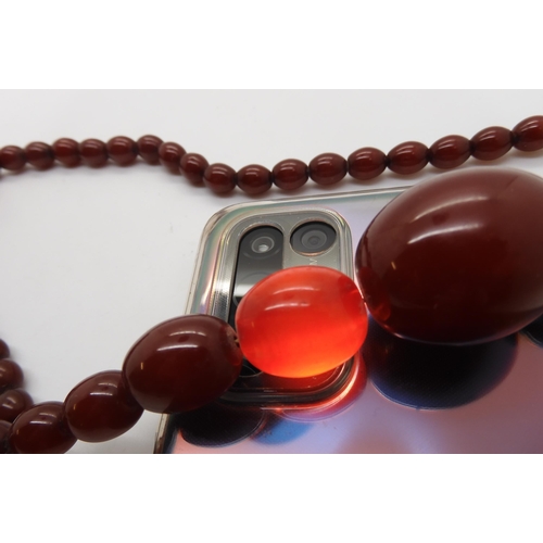 596 - A string of cherry amber coloured beads