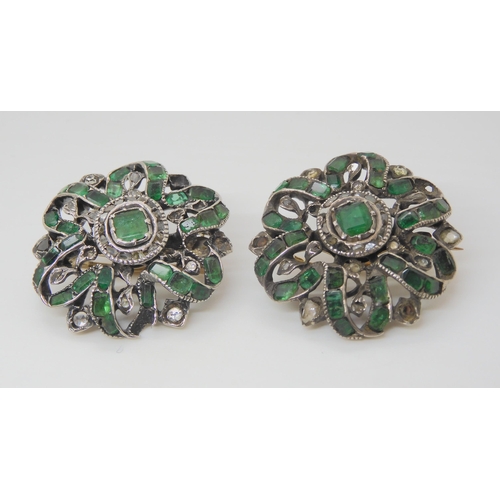 2729 - A PAIR OF EMERALD AND DIAMOND BROOCHESthe gems set into white metal mounts with yellow metal pins an... 