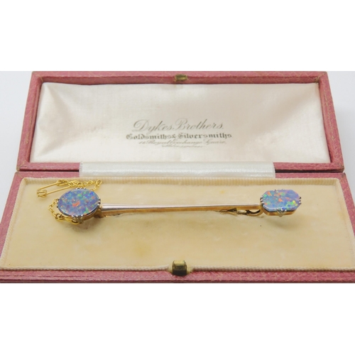 2737 - AN OPAL BAR BROOCHthe yellow and white metal bar brooch, is set with two lively opal doublets. Brooc... 