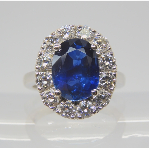 2741 - A SAPPHIRE AND DIAMOND CLUSTER RINGset throughout in 18ct white gold, set with an oval mixed cut sap... 