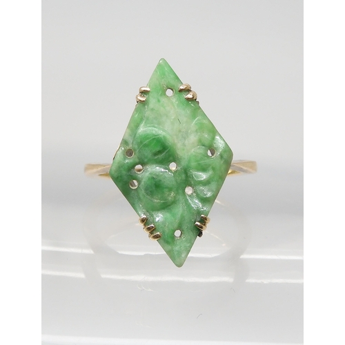 2748 - A CHINESE GREEN HARDSTONE RINGset with a lozenge shaped plaque, carved with fruit. In a 9ct gold mul... 