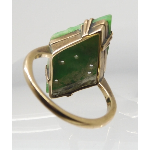 2748 - A CHINESE GREEN HARDSTONE RINGset with a lozenge shaped plaque, carved with fruit. In a 9ct gold mul... 