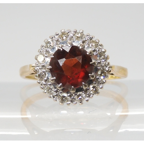 2749 - A GARNET AND DIAMOND CLUSTER RINGmounted throughout in 18ct gold, the garnet is approx 7mm, and set ... 