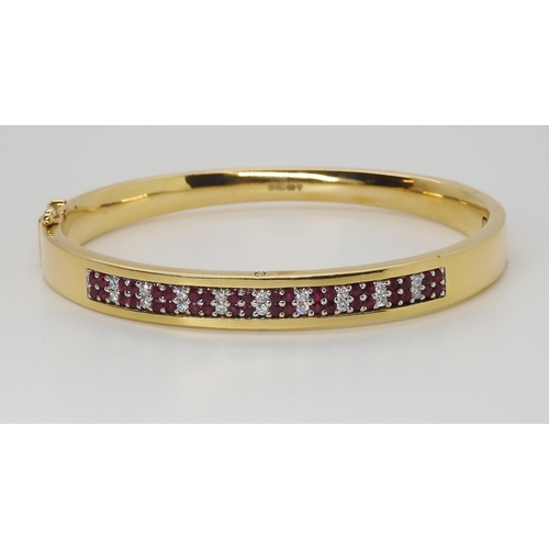 2765 - AN 18CT GOLD RUBY AND DIAMOND BANGLEmade by Lime Blue, full London import marks. with a diamond deta... 