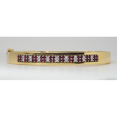 2765 - AN 18CT GOLD RUBY AND DIAMOND BANGLEmade by Lime Blue, full London import marks. with a diamond deta... 