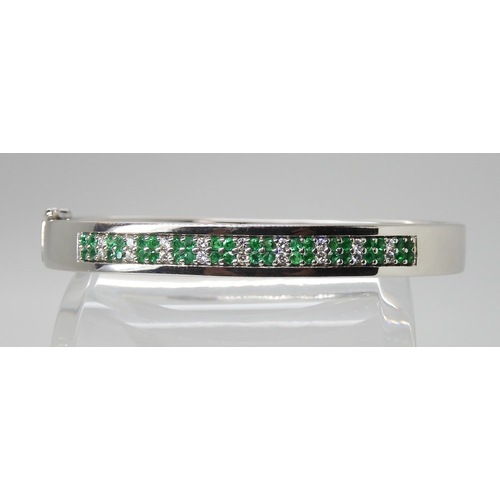 2767 - AN 18CT GOLD EMERALD AND DIAMOND BANGLEmade by Lime Blue, full London import marks. with a diamond d... 
