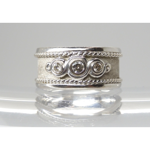 2801 - A 9CT WHITE GOLD DIAMOND RINGthe wide band ring is set with three diamonds, with an approximate diam... 