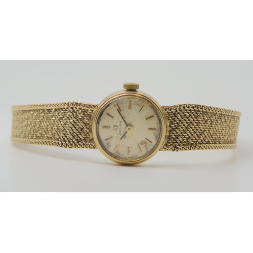 2904 - A 9CT GOLD LADIES OMEGAwith integral textured strap, cream dial with gold coloured baton numerals, w... 