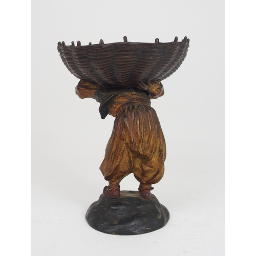 2210 - AN EARLY 20TH CENTURY COLD PAINTED BRONZE OF A BOY wearing a fez, and carrying a large basket on his... 