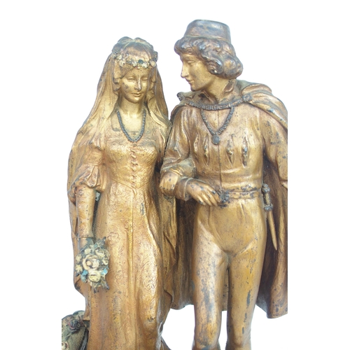 2211 - A GILDED BRONZE AND COLD PAINTED BERGMAN GROUP OF A BRIDE AND GROOMmodelled walking down steps strew... 