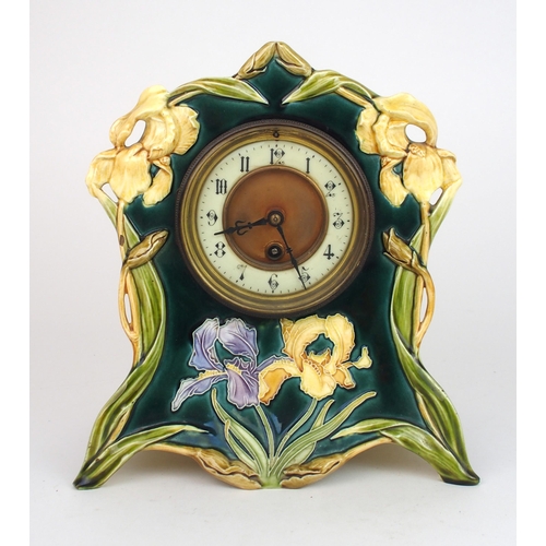 2226 - A CONTINENTAL POTTERY CLOCKthe case relief moulded with irises on a dark green ground, 26.5cm high, ... 