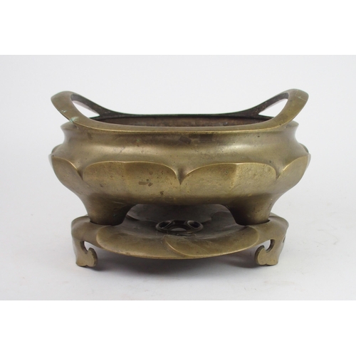 2401 - A LARGE CHINESE BRASS CENSER the raised twin handles above lotus lobed sides and on tripod feet and ... 