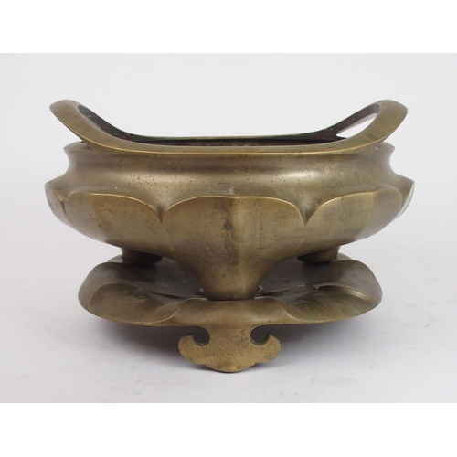 2401 - A LARGE CHINESE BRASS CENSER the raised twin handles above lotus lobed sides and on tripod feet and ... 