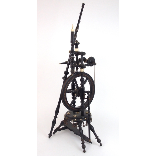 2567 - A CONTINENTAL EBONISED SPINNING WHEEL OF SMALL PROPORTIONS Ornately turned, with decorative car... 