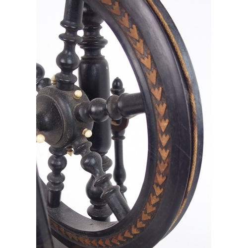 2567 - A CONTINENTAL EBONISED SPINNING WHEEL OF SMALL PROPORTIONS Ornately turned, with decorative car... 