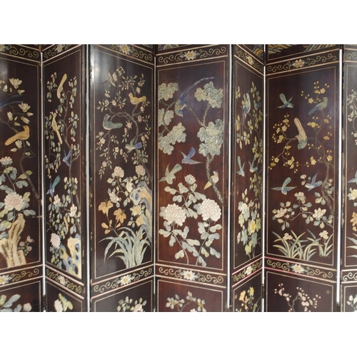 2015 - AN EARLY 20TH CENTURY CHINESE LACQUERED EIGHT PANEL DRAUGHT SCREENextensively inlaid to both sides w... 