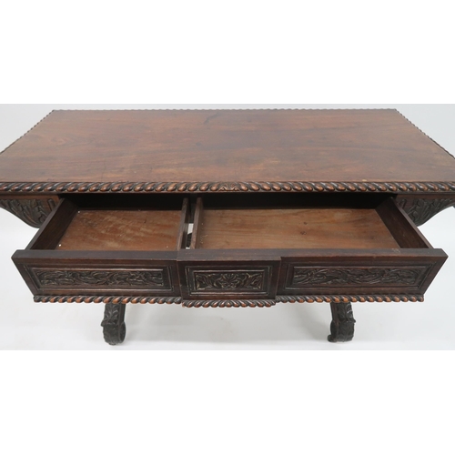 2026 - AN ANGLO-INDIAN ROSEWOOD LIBRARY TABLEwith rectangular gadrooned top over a pair of asymmetrical fol... 