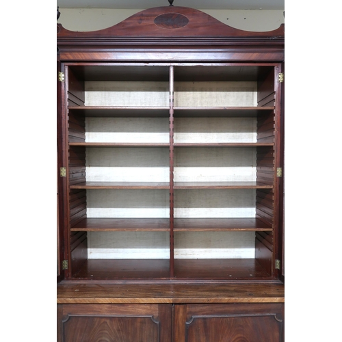 2034 - A 19TH CENTURY MAHOGANY BREAKFRONT LIBRARY BOOKCASEwith moulded serpentine cornice topped with turne... 