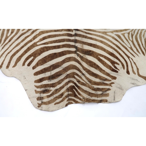 2038 - A 20TH CENTURY BROWN AND WHITE PRINTED COWHIDE RUGrug is 182cm long x 182cm wide... 