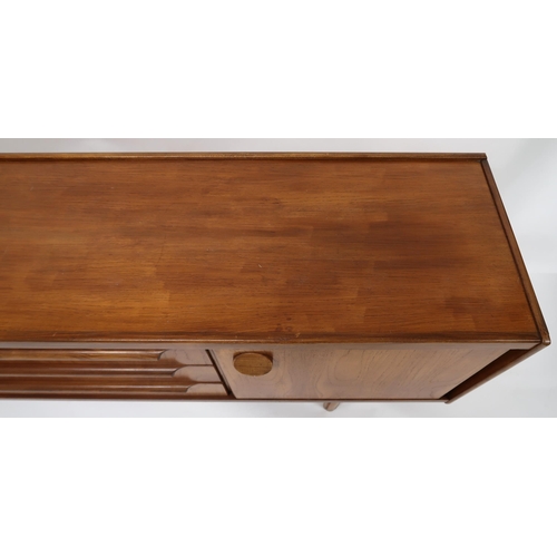 2129 - A MID 20TH CENTURY TEAK SIDEBOARD with three central drawers with shaped drawer pulls flanked by cab... 