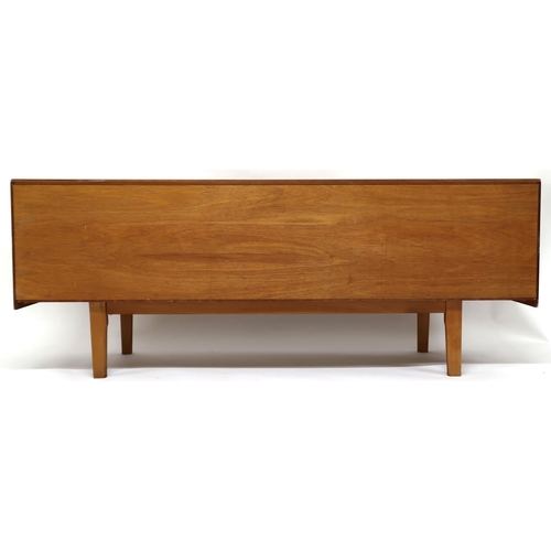 2129 - A MID 20TH CENTURY TEAK SIDEBOARD with three central drawers with shaped drawer pulls flanked by cab... 