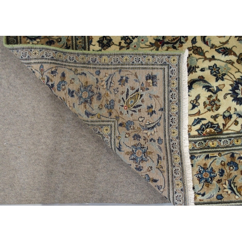 2134 - A CREAM GROUND KASHAN RUGwith all over floral ground and flower head border, 297cm long x 194cm wide... 