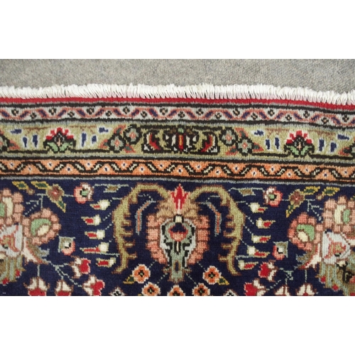 2135 - A RED GROUND TABRIZ RUGwith dark blue and cream central medallion, matching spandrels and a dark blu... 
