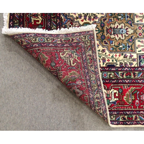 2138 - A CREAM GROUND TABRIZ RUGwith all-over multicoloured floral geometric design and red flower head bor... 