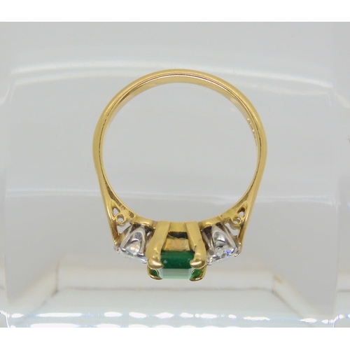 2703 - AN EMERALD AND DIAMOND RINGthe 18ct gold ring set with a step cut emerald 8mm x 6mm, and two diamond... 