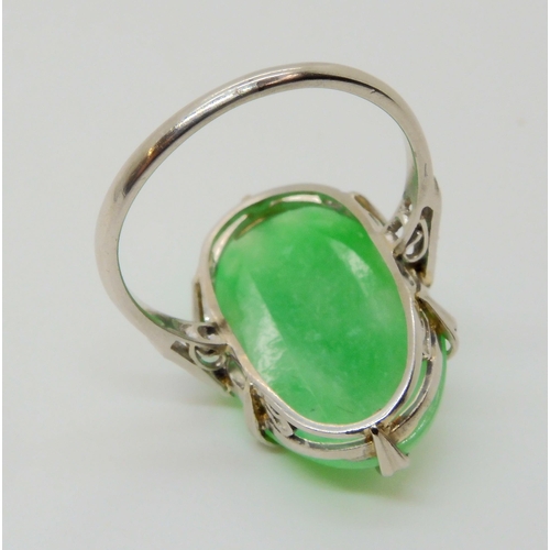 2708 - A CHINESE GREEN HARDSTONE RINGthe platinum handmade ring has a pretty scrolled gallery and three ros... 