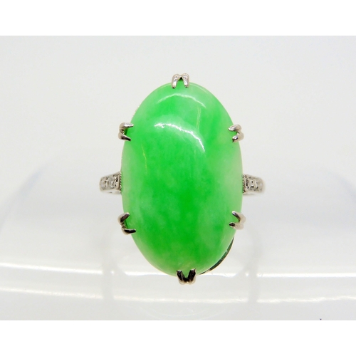 2708 - A CHINESE GREEN HARDSTONE RINGthe platinum handmade ring has a pretty scrolled gallery and three ros... 