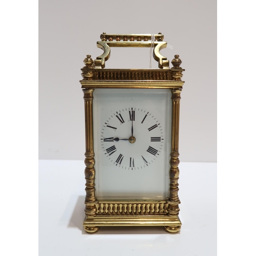 298 - A French brass and glass carriage clock with column supports and galleried detail, with travel case ... 