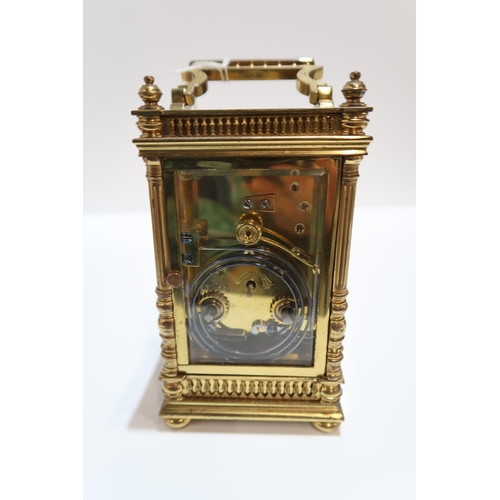 298 - A French brass and glass carriage clock with column supports and galleried detail, with travel case ... 