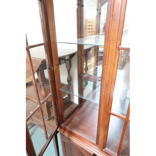 146 - A 20th century mahogany glazed display cabinet with moulded cornice over pair of glazed doors over p... 