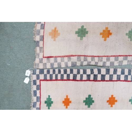 163 - A pair of beige ground Tibetan rugs with geometric design, 145cm long x 80cm wide (2)