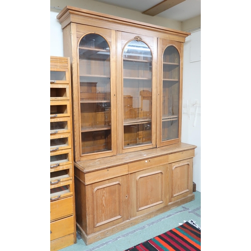 165 - A late Victorian pine library bookcase with moulded cornice over three glazed doors on base with thr... 