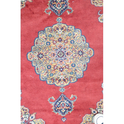 209 - A red ground Keshan style rug with beige central medallion, matching spandrels and multicoloured bor... 