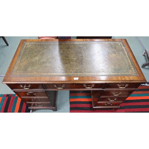 29 - A 20th century mahogany pedestal writing desk with green leather skiver over single drawer flanked b... 