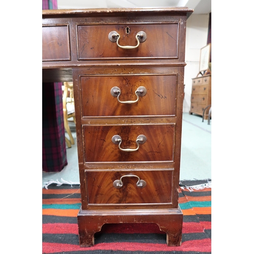 29 - A 20th century mahogany pedestal writing desk with green leather skiver over single drawer flanked b... 