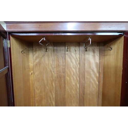 43 - An Edwardian mahogany wardrobe with shaped cornice over central mirrored door flanked by panel doors... 