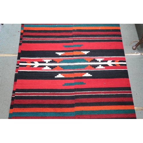 67 - An approximate pair of Zapotec Mexican rugs with geometric central medallion on multicoloured stripe... 