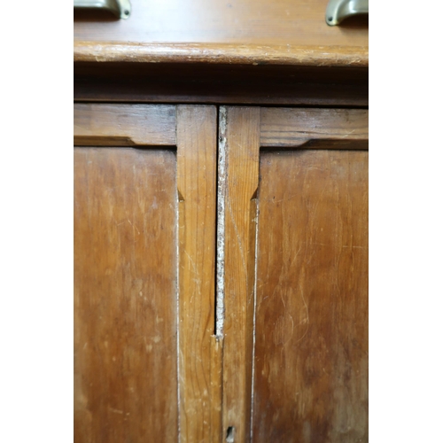 74 - A Victorian pine narrow glazed bookcase with pair of glazed doors over single drawer over pair of ca... 