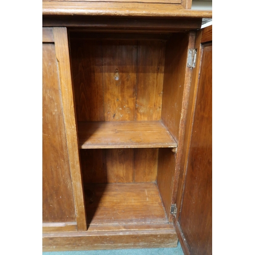 74 - A Victorian pine narrow glazed bookcase with pair of glazed doors over single drawer over pair of ca... 