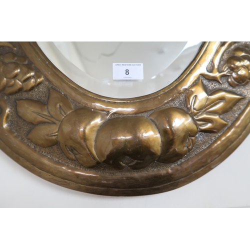 8 - An early 20th century oval brass framed bevelled glass wall mirror with embossed fruit on the vine d... 