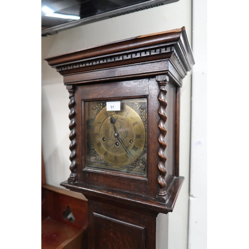 91 - A 20th century stained oak grandmother clock with brass face bearing Roman numerals, 169cm high x 35... 