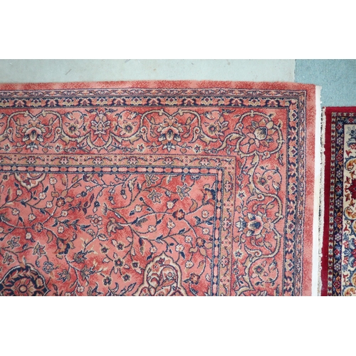 97 - A large machine woven terracotta ground rug with allover floral/foliate design with flower head bord... 