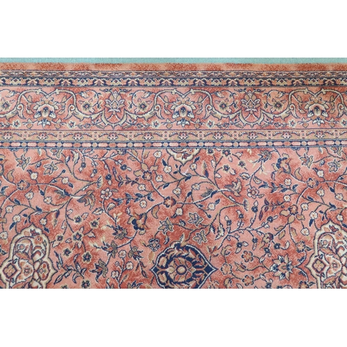 97 - A large machine woven terracotta ground rug with allover floral/foliate design with flower head bord... 