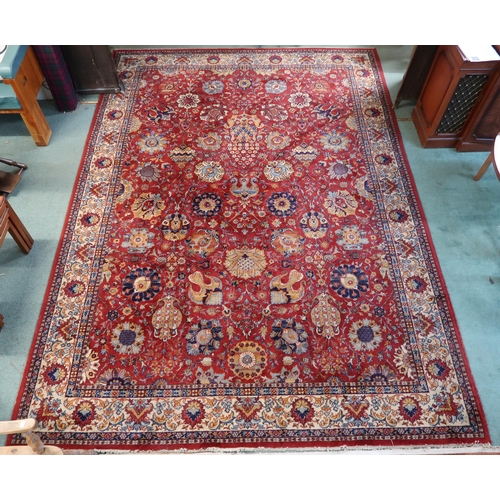 98 - A red ground Persian style rug with allover flowerhead design and flowerhead border, 352cm long x 24... 