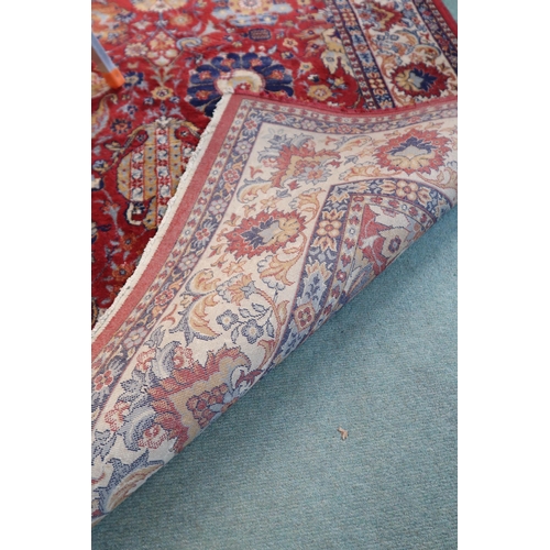 98 - A red ground Persian style rug with allover flowerhead design and flowerhead border, 352cm long x 24... 